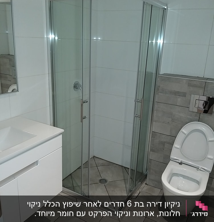מקלחון זכוכית ושירותים בחדר אמבטיה נקי